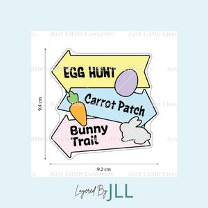 Puede incluir: Una pegatina en capas con tres flechas direccionales en colores pastel. La flecha superior dice "Egg Hunt", la del medio "Carrot Patch" y la inferior "Bunny Trail". Incluye una zanahoria, un huevo y un conejito. Mide 9,4 cm x 9,2 cm.