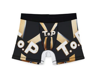 May include: Black boxer briefs with a gold and white geometric pattern and the text "T.O.P." repeated across the front. The waistband is black, and the pouch is white.