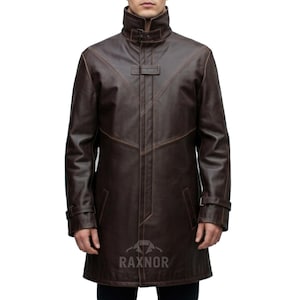 May include: A brown leather coat with a high collar and a button closure. The coat has a long length, reaching the mid-thigh. It features decorative stitching and a buckle detail on the sleeves. The coat is a rich, dark brown color.