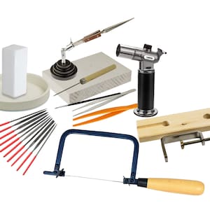 Può includere: Un set di strumenti per la creazione di gioielli che include una sega, lime, pinzette, una torcia, un saldatore, un blocco di legno e una pinza.