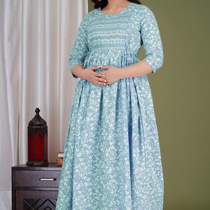 K&ouml;nnte beinhalten: Hellblaues Kleid mit floralem Druck und Dreiviertel&auml;rmeln. Das Kleid hat einen runden Ausschnitt mit detailliertem Muster und eine geraffte Taille. Der Rock ist im flie&szlig;enden A-Linien-Stil gehalten. Geeignet f&uuml;r Freizeit- oder halbformelle Anl&auml;sse.