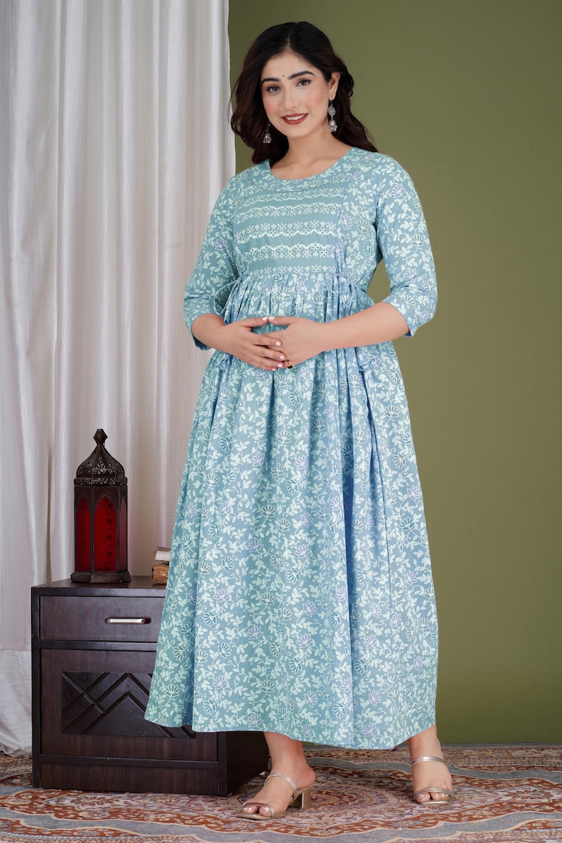 K&ouml;nnte beinhalten: Hellblaues Kleid mit floralem Druck und Dreiviertel&auml;rmeln. Das Kleid hat einen runden Ausschnitt mit detailliertem Muster und eine geraffte Taille. Der Rock ist im flie&szlig;enden A-Linien-Stil gehalten. Geeignet f&uuml;r Freizeit- oder halbformelle Anl&auml;sse.