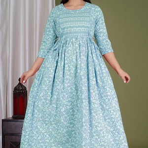 K&ouml;nnte beinhalten: Hellblaues Kleid mit floralem Druck, Dreiviertel&auml;rmeln und rundem Ausschnitt. Das Kleid hat eine betonte Taille und einen flie&szlig;enden Rock. Der Stoff hat ein zartes Blumenmuster in Wei&szlig; und Lila. Das Kleid ist f&uuml;r Freizeitkleidung geeignet.
