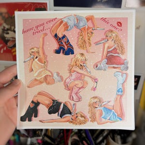 May include: A square print featuring illustrations of a blonde woman in various poses, each holding a microphone. The woman is wearing different outfits, including a red dress, a pink outfit, and a blue outfit. The print has text that reads "have you ever tried... this one?"