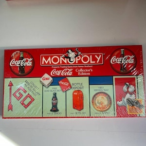 May include: A sealed Coca-Cola Monopoly Collector's Edition board game. The red box features the Coca-Cola logo and Monopoly branding. The game board includes images of a Coke bottle, dice, and a serving tray.