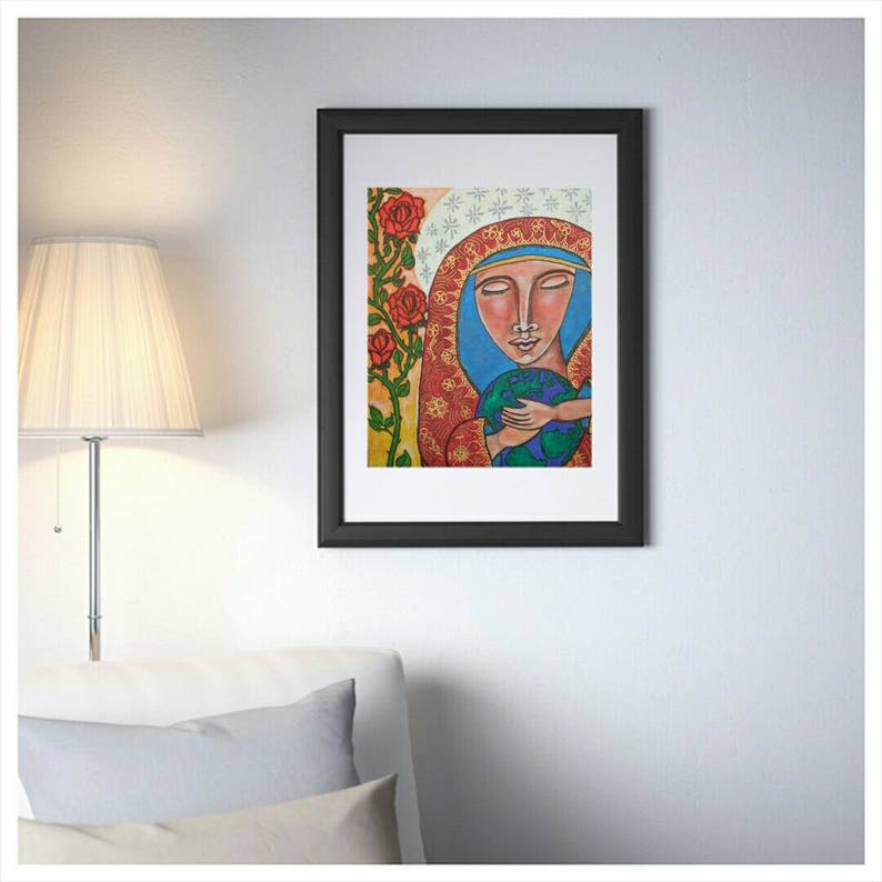 K&ouml;nnte beinhalten: Gerahmter Kunstdruck mit einer stilisierten Darstellung einer Figur, die einen Globus h&auml;lt. Das Kunstwerk hat einen ruhigen Ausdruck, mit einer blauen Kopfbedeckung und einem rot-gold gemusterten Gewand. Rote Rosen und gr&uuml;nes Laub sind im Hintergrund. Der Rahmen ist schwarz.
