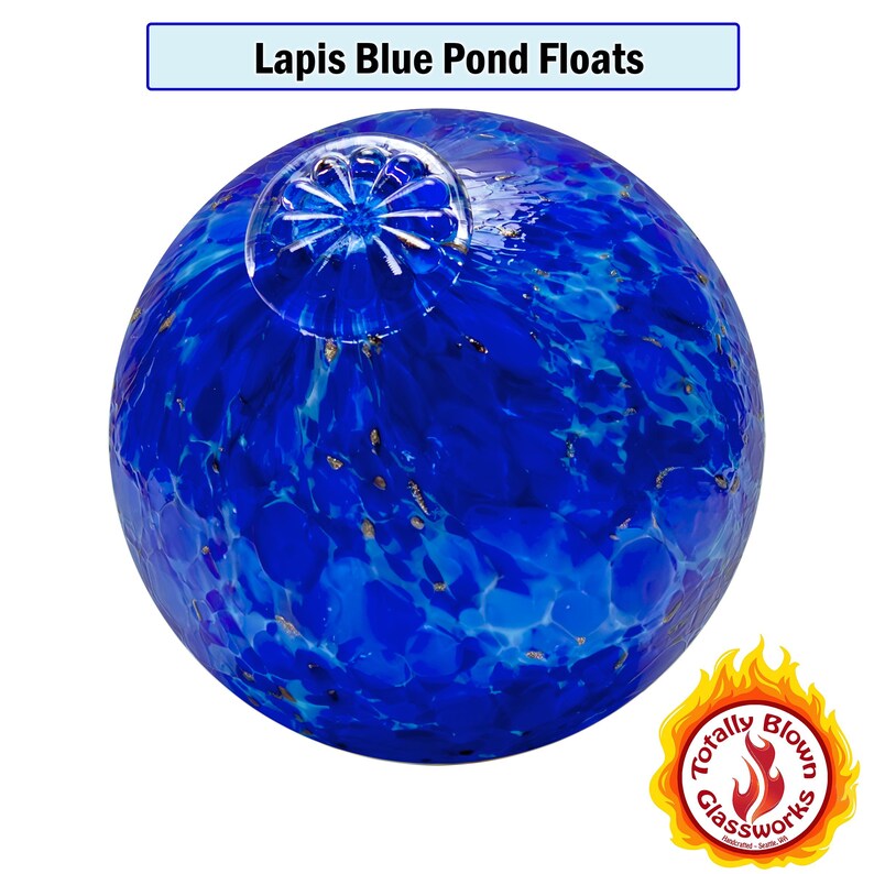 May include: A blue glass pond float with a swirling pattern and gold flecks. The float is round and has a flat top. The float is made by Totally Blown Glassworks.