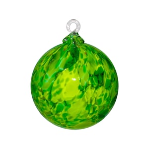 May include: A green glass Christmas ornament with a swirl pattern and white accents.