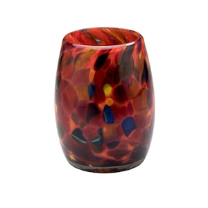 May include: A red, orange, and blue glass candle holder with a speckled pattern.