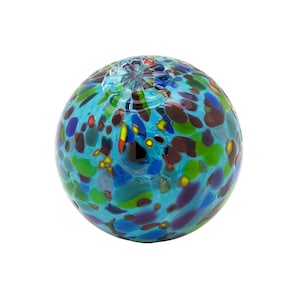May include: A blue glass sphere with a mottled pattern of green, brown, yellow, and blue. The sphere is made of glass and has a smooth, shiny surface.