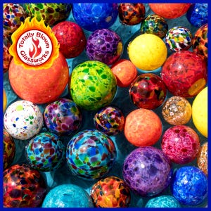 May include: A collection of colorful glass orbs with speckled patterns, floating in a blue pool of water. The orbs are various sizes and shapes, with colors including red, orange, yellow, green, blue, purple, and white. The image includes the logo "Totally Blown Glassworks".