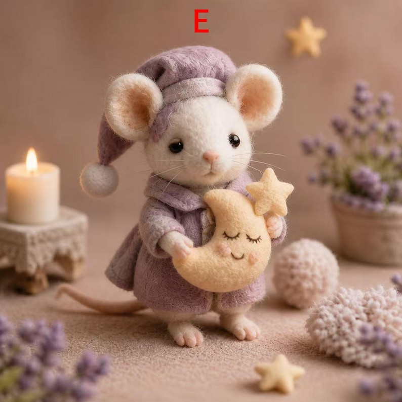 Peut inclure: Une souris en feutre faite &agrave; la main, v&ecirc;tue d'un bonnet de nuit et d'un manteau lavande, tenant une lune et une &eacute;toile en forme de croissant jaunes. La souris a de grandes oreilles rondes et se trouve pr&egrave;s d'une bougie allum&eacute;e et d'&eacute;toiles d&eacute;coratives.