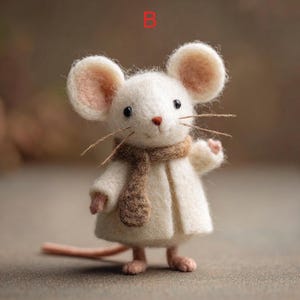 Peut inclure: Une figurine de souris en feutre faite &agrave; la main. La souris est blanche avec de grandes oreilles doubl&eacute;es de rose, une &eacute;charpe marron et un manteau cr&egrave;me. Elle a une longue queue rose et se tient debout. La figurine a des yeux noirs et de longues moustaches.