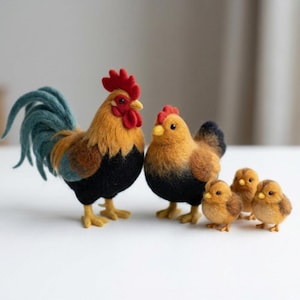 May include: A set of needle-felted wool figures featuring a cockerel with a red comb and blue tail feathers, a hen, and three small chicks. Each bird has a textured, fuzzy appearance with black, brown, and yellow colouring throughout the group.