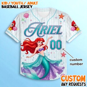 A white baseball jersey with a design featuring the character Ariel from the Disney movie "The Little Mermaid". The jersey has a mermaid illustration and the name "Ariel" printed on it.
