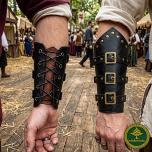 May include: Two leather arm bracers. One is black and brown with a lace-up design and brass eyelets. The other is black with three brass buckles and brass studs. The bracers are worn on the forearms.