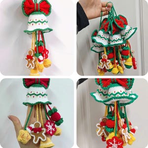 May include: Crocheted Christmas bell ornament with a red bow, white bell with green trim, and dangling ornaments including gingerbread men, berries, and snowflakes. The bell is a festive holiday decoration.