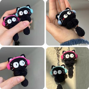 Könnte beinhalten: Gehäkelte schwarze Katzen-Schlüsselanhänger mit großen weißen Augen, die rosa und blaue Kopfhörer tragen. Die Schlüsselanhänger haben einen kleinen Schwanz und werden in mehreren Ansichten gezeigt, einschließlich in der Hand gehalten und an einer Kette hängend.