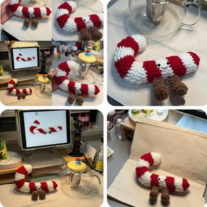Puede incluir: Un bastón de caramelo de ganchillo con rayas rojas y blancas, con una cara sonriente y piernas marrones. La decoración navideña hecha a mano está rizada y tiene un diseño caprichoso.