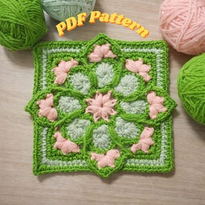 Peut inclure: Un motif de crochet carré vert et vert clair avec des accents de fleurs roses. Les mots "PDF Pattern" sont en texte orange en haut. Des pelotes de fil vert et rose sont en arrière-plan.