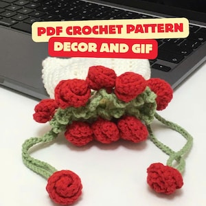 Könnte beinhalten: Handgefertigtes gehäkeltes Blumendesign mit roten Rosen und grünen Blättern. Der Text "PDF CROCHET PATTERN DECOR AND GIF" ist im Bild zu sehen. Das gehäkelte Stück ist wahrscheinlich für Dekoration oder zum Verschenken gedacht.