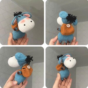May include: A handmade crochet donkey doll in shades of blue, white, and orange. The donkey has a white head with pink cheeks, blue ears, and a small orange backpack. The doll is a charming, whimsical creation.