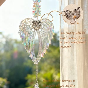 May include: A clear crystal angel wing suncatcher with iridescent highlights. The suncatcher features a chain with a crystal pendant and a small locket. Text on the image reads "Custom Your Name" and "Each chime carries a thought of you on the wind."