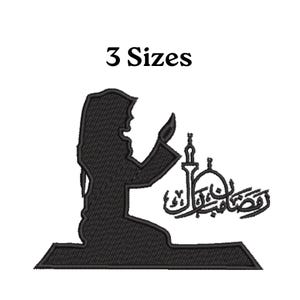 May include: Black embroidered design featuring a silhouette of a person praying, a mosque, and Arabic calligraphy. The text "3 Sizes" is above the design. The design is on a white background.