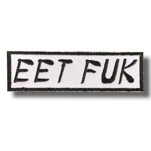 Könnte beinhalten: Rechteckiger, gestickter Aufnäher mit dem Text "EET FUK" in Schwarz auf weißem Grund. Der Aufnäher hat einen schwarzen Rand und ist zum Aufnähen oder Aufbügeln auf Stoff vorgesehen.