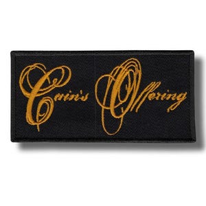 May include: Black rectangular patch with the embroidered text "Cain's Offering" in gold script. The patch has a black border and is likely designed to be sewn onto clothing or accessories.