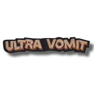 Könnte beinhalten: Gestickter Aufnäher mit dem Schriftzug "ULTRA VOMIT" in einem 3D-Schriftstil. Der Text ist hellbraun mit einer dunkelbraunen Umrandung, vor einem schwarzen Hintergrund. Der Aufnäher hat eine rechteckige Form.