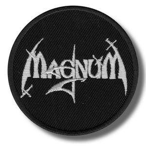 May include: A circular, black embroidered patch with the word "Magnum" in white, gothic-style lettering. Small crosses are incorporated into the design. Suitable for clothing or accessories.