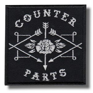 Puede incluir: Parche cuadrado negro con texto y diseño bordados en blanco. El texto dice "COUNTER PARTS" en un diseño arqueado. El diseño incluye flechas, una rosa y formas geométricas. El parche tiene un borde negro.