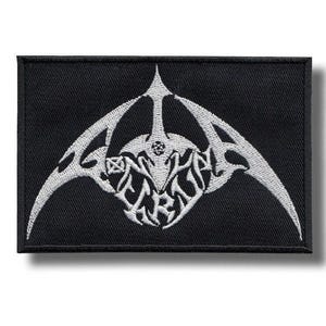 May include: Black rectangular patch with a white embroidered design. The design features a stylized emblem with curved lines and intricate details, possibly for a band or organization. The patch is likely for clothing or accessories.