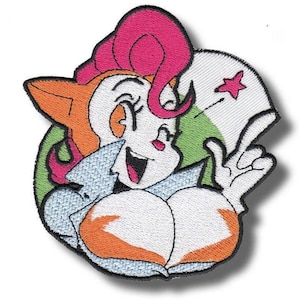 May include: Embroidered patch of a cartoon character with orange hair, a pink bow, and a white face. The character is smiling and giving a peace sign. The patch has a black border and a green and white background.