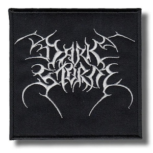 May include: Square black patch featuring white embroidered text, reading "DARK TRIBE" in a gothic style font. The patch has a black border and is designed for application on clothing or accessories.