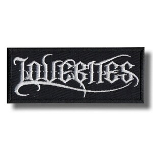May include: Black rectangular patch with the word "Inferites" embroidered in white gothic lettering. The patch has a black border and a white background for the text. The design is a stylized, decorative font.