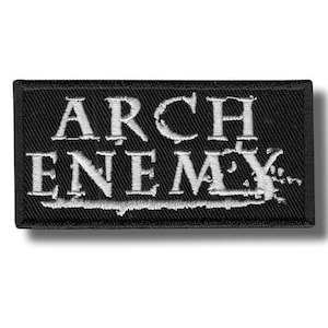 Könnte beinhalten: Ein rechteckiger, schwarzer Aufnäher mit dem weißen, gestickten Schriftzug "ARCH ENEMY". Der Aufnäher hat eine strukturierte Oberfläche und einen weißen Rand. Das Design ist in einem kräftigen, gotischen Stil gehalten.