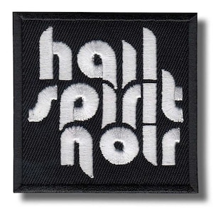 May include: Square black embroidered patch with the words "hall spirit noir" in white, stylized, embroidered lettering. The patch has a black border and is likely designed to be sewn onto clothing or accessories.