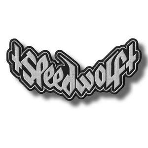 May include: A black and white embroidered patch with the text "Speedwolf" in a stylized font. The patch has a black border and a white interior, creating a bold contrast. The design is slightly curved.