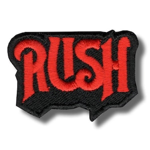 Pode incluir: Patch bordado com a palavra "RUSH" em letras vermelhas estilizadas. O patch tem uma borda preta com uma forma irregular. O texto apresenta um redemoinho decorativo no "R". Adequado para aplicar em roupas ou acessórios. Mede aproximadamente 8 cm de comprimento.