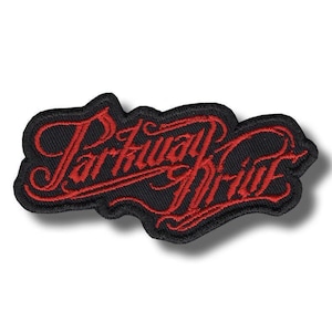 Puede incluir: Parche bordado con las palabras "Parkway Drive" en letras rojas sobre un fondo negro. El parche tiene una forma irregular y una apariencia texturizada, lo que sugiere un material de tela.