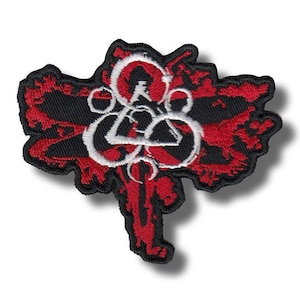May include: Embroidered patch featuring a red and black design with a white emblem. The patch has a unique shape with a black border and a white emblem in the center. The design is detailed and eye-catching.