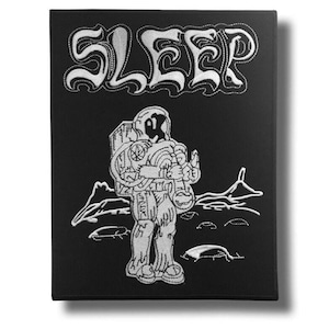 May include: Black embroidered patch featuring the word "SLEEP" in white, stylized lettering. Below, a detailed white illustration of an astronaut stands on a lunar surface. The astronaut holds an object, with a mountain range in the background.