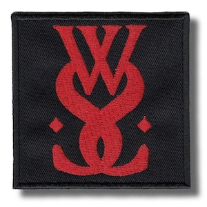 May include: Black square patch with a red stylized monogram design. The monogram appears to be the letters "W" and "S" intertwined. Two small red diamond shapes are on either side of the monogram.