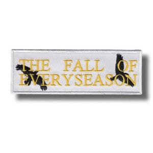 Può includere: Una toppa rettangolare bianca con testo ricamato in oro che recita "THE FALL OF EVERYSEASON". Due sagome di uccelli neri affiancano il testo. La toppa ha un bordo bianco.
