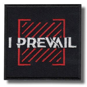Puede incluir: Parche cuadrado negro con las palabras "I PREVAIL" bordadas en blanco. El texto está superpuesto a un diseño de rayas rojas en ángulo dentro de un marco cuadrado rojo. El parche tiene un borde negro.