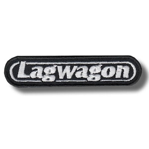 May include: Black and white embroidered patch with the word "Lagwagon" in white, stylized lettering. The patch has a black background and a white border. The patch is rectangular with rounded corners.