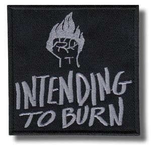 Op de afbeelding: Zwart vierkantige patch met de tekst "INTENDING TO BURN" in grijs. Boven de tekst staat een grijze afbeelding van een vuist in vlammen. De patch heeft een zwarte rand.