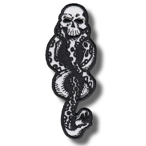 May include: Embroidered patch featuring a black snake intertwined with a skull. The patch has a white background and a black border. The design is detailed with intricate stitching, creating a textured appearance. The patch is likely for clothing or accessories.